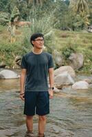 Asian Model, Adventurous Hiking Amid Sentul's Pine Forests, Crossing River, Embracing Nature's Beauty in Indonesia photo