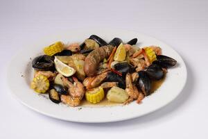 SHRIMPS AND MUSSELS CLAWDADDY BOIL in a dish top view on grey background singapore food photo