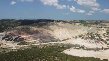 aéreo Visão industrial do aberto mineração pedreira com grande quantidade do maquinaria às trabalhos - extração fluxos para a metal indústria. oval mineração industrial cratera, ácido meu drenagem dentro Rocha. video