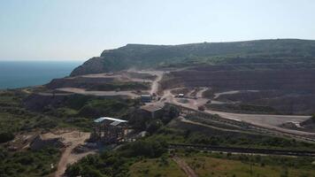 Aerial view of industrial opencast mining quarry with lots of machinery at work - extracting fluxes for the metal industry. Oval mining industrial crater, acid mine drainage in rock. video