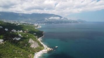 aéreo ver de yalta, Crimea y ayu-dag oso montaña a brillante soleado día terminado el negro mar. rock parus en gaspra cerca de golondrina nido en Crimea. video