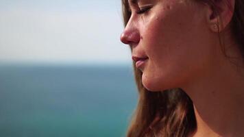 mujer comiendo lechoso almendra nueces. un joven caucásico mujer comiendo Fresco almendra después Mañana aptitud yoga cerca mar. sano vegano alimento. lento movimiento video