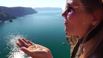 mujer comiendo lechoso almendra nueces. un joven caucásico mujer comiendo Fresco almendra después Mañana aptitud yoga cerca mar. sano vegano alimento. lento movimiento video