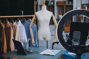 Beautiful asian woman blogger showing bag in front of camera to recording vlog video live streaming at her shop.Business online influencer on social media concept. photo