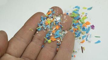 Close-up on many microplastic particles in human hand. Concept of plastic pollution with nanoplastics. Soft focus on a micro plastic particles that cannot be recycled photo