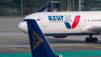 PHUKET, THAILAND - FEBRUARY 26, 2023. Boeing 767, RA-73080 of AzurAir taxiing at Phuket airport, side view, medium shot. Travel concept video