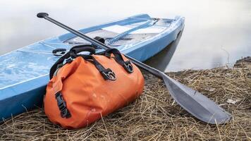 turismo estar arriba paddleboard con un paleta y la seguridad Correa en un lago costa, temprano primavera en Colorado foto