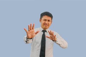 Adult asian man screaming ekspression scared while his hands doing stop gesture photo