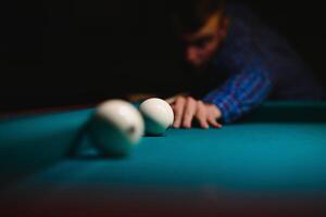 the player takes aim at the ball in Billiards photo