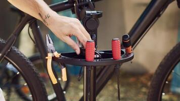 Close-up glimpse of finely-tuned tools carefully being arranged on repair stand waiting for bicycle maintenance activities to take place. Man organizing equipment for bike servicing. photo