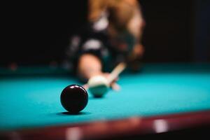 the player takes aim at the ball in Billiards photo