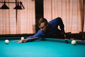 the player takes aim at the ball in Billiards photo