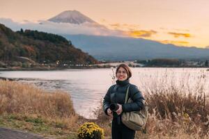 Woman tourist with Fuji Mountain at Lake Kawaguchi, happy Traveler sightseeing Mount Fuji in Fujikawaguchiko, Yamanashi, Japan. Landmark for tourists attraction. Japan Travel, Destination and Vacation photo