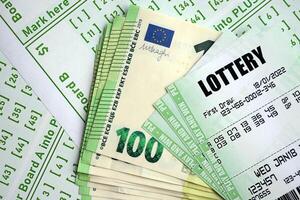 Green lottery tickets and euro money bills on blank with numbers for playing lottery photo