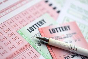 Green and red lottery tickets with pen on blank bills with numbers for playing lottery photo