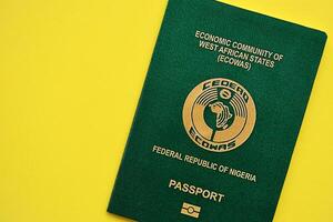 Green Nigerian passport on yellow background close up photo