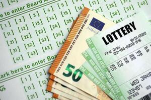 Green lottery tickets and euro money bills on blank with numbers for playing lottery photo