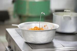 Metal bowl with food in the industrial kitchen photo