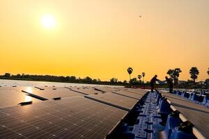 fotovoltaica ingenieros trabajo en flotante fotovoltaica. trabajadores inspeccionar y reparar el solar panel equipo flotante en agua. ingeniero trabajando preparar flotante solar paneles plataforma sistema en el lago. foto