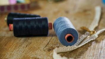 Colored spools of thread on wooden table. Sewing concept. photo