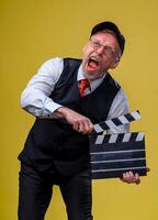 Man holds film flap. Male in cap with open mouth. Film directing. Film production. Human emotions. Close up. photo