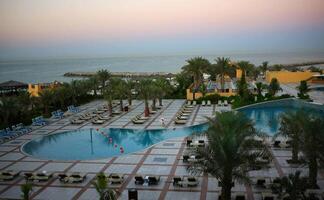 Poolat hotel. View from above at resort. Palms and water. Sunset at empty hotel. No people. photo