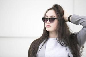 hermosa joven niña con largo pelo en gafas de sol.retrato de un mujer en el calle foto