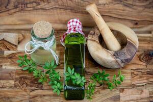 green Woodruff vinegar on olive wood photo