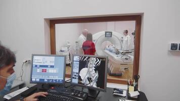 ukraina kyiv 10.03.2024 medicinsk tekniker monitorer ct skanna, sjukvård professionell analyser en ct skanna på dator skärmar i en medicinsk kontor. video