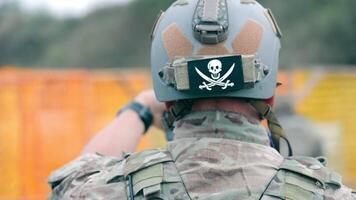 Ukraine. Bahmut 10.09.2023 Military training camp. A soldier's head from behind, close-up. A military helmet depicting a skull and two sabers. video