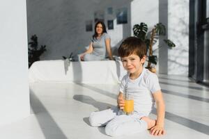 mom with son in pajamas eating fruit on bed. portrait happy, smiling, joyful family, mothen and son having breakfast in bed, surprise on mom day. Positive human emotions photo