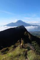 encima nube nueve, montar batur cima, asiático hombre excursionista debajo azur cielo y nube mar foto