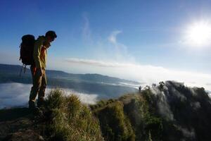 Above Cloud Nine, Mount Batur's Peak, Asian Man Trekker under Azure Sky and Cloud Sea photo