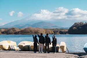 tourists enjoy with Fuji Mountain at Lake Shoji, happy friends group travel Mount Fuji and road trip Fuji Five Lakes. Landmark for tourists attraction. Japan Travel, Destination and Vacation concept photo