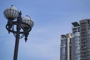 The street lanterns against a skycaper and sky background. photo