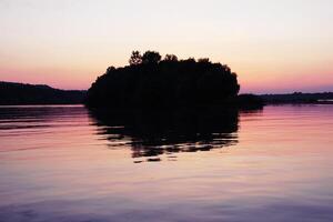hermosa puesta de sol en el Danubio río en voivodina, serbia isla con reflexión en rosado cielo y agua. foto