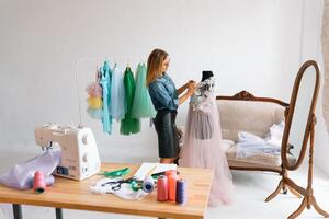 happy young fashion deisgner in her studio. concept of tailoring photo