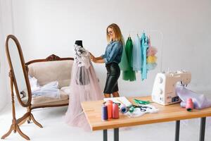 happy young fashion deisgner in her studio. concept of tailoring photo