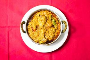 Chicken karahi, indian spicy chicken masala isolated on background top view of pakistani chic photo