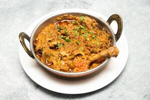 Chicken karahi, indian spicy chicken masala isolated on background top view of pakistani chicken karai photo