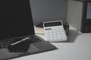 Flat lay, top view office table desk. Workspace with calculator,pen,laptop on white background.Copy Space for text,Empty Blank to word.Business Finance,Education Technology.Work from home. photo