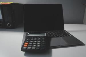 Flat lay, top view office table desk. Workspace with calculator,pen,laptop on white background.Copy Space for text,Empty Blank to word.Business Finance,Education Technology.Work from home. photo