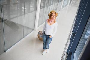 Woman walking with suitcase on the airport terminal,travel concept. High season and vacation concept. Relax and lifestyles. Travel and Holiday Concept. photo