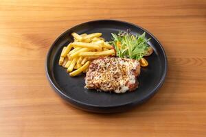 Breaded Crispy Pork Parmigiana with french fries and salad served in dish isolated on table top view of thai food photo