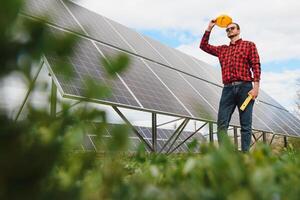 solar paneles y azul cielo.hombre en pie cerca solar paneles solar panel produce verde, ambientalmente simpático energía desde el Dom. foto