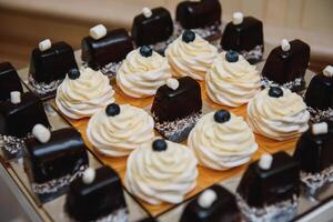 Delicious sweets on wedding candy buffet with desserts, cupcakes,tiramisu and cookies photo