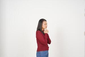joven asiático mujer en rojo camiseta cerrado ojo doblez mano y Orando aislado en blanco antecedentes foto