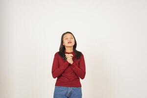 Young Asian woman in Red t-shirt closed eye fold hand and praying isolated on white background photo