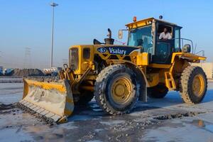 Groomer in the Middle East. Grader Parked on Concrete Slabs at an Industrial Complex photo