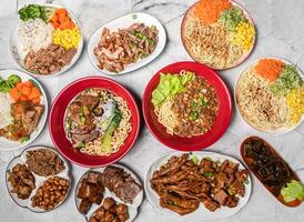 Assorted Braised beef noodles, Meat, Donburi, Flax and Pesto Cold Noodles, kelp, chicken feet, Chicken Bento, peanut, dried tofu, pig feet served in dish isolated on table top view of taiwan food photo